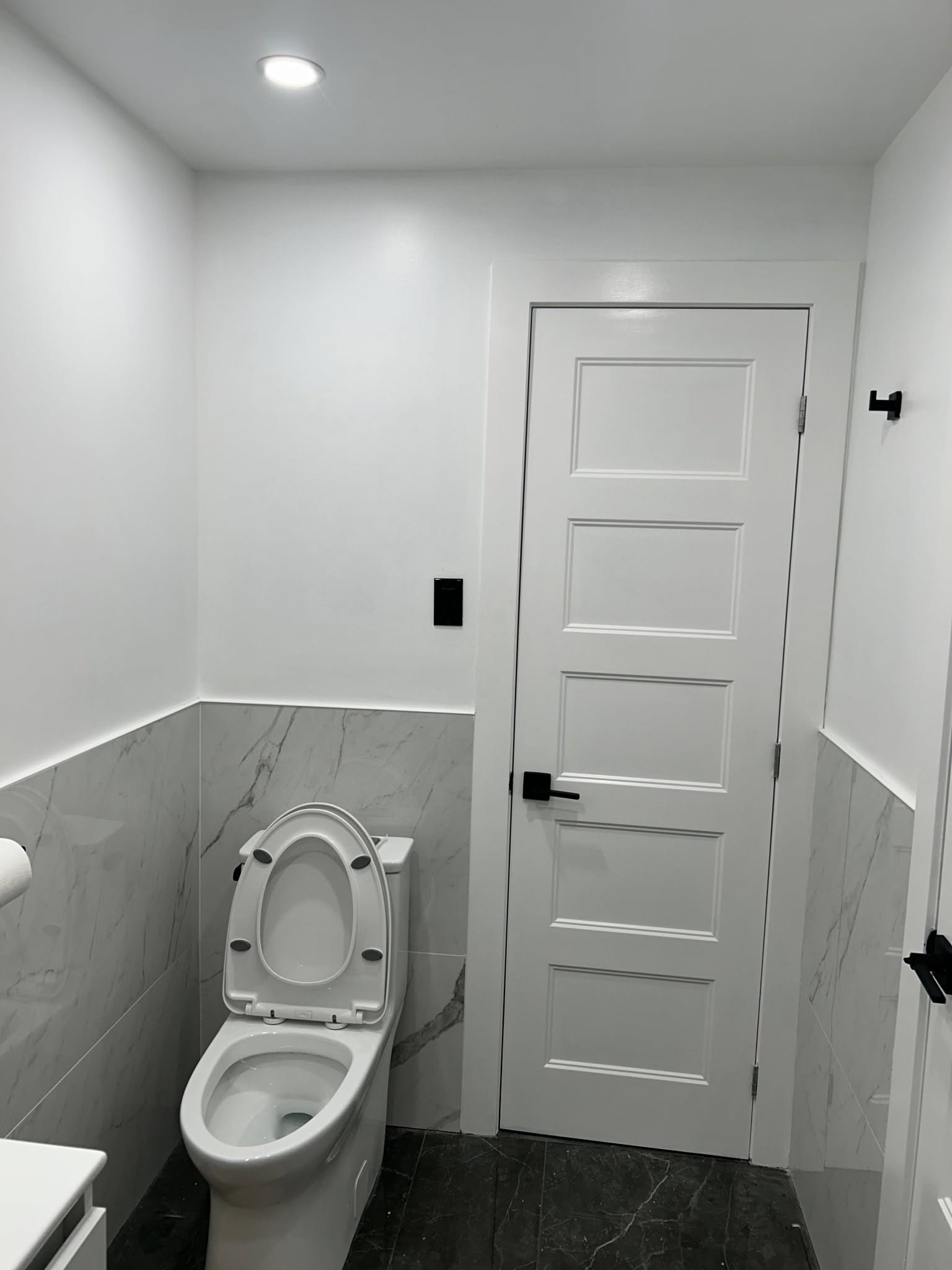 Cuisine contemporaine avec îlot central en bois clair, tabourets et hotte suspendue dans un intérieur résidentiel  à Saint-Bruno-de-Montarville